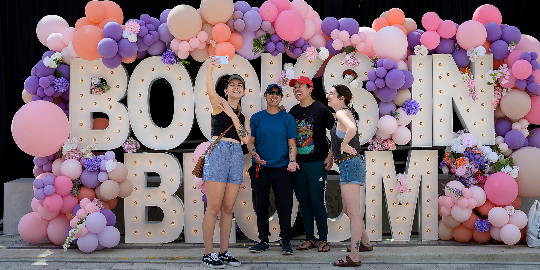 Books in Bloom People stand in front of Books in Bloom balloon display at Merriweather District.