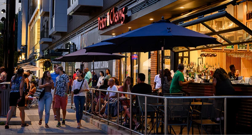 People walk in front of Peter Chang's outdoor dining at Merriweather District, Columbia, MD.