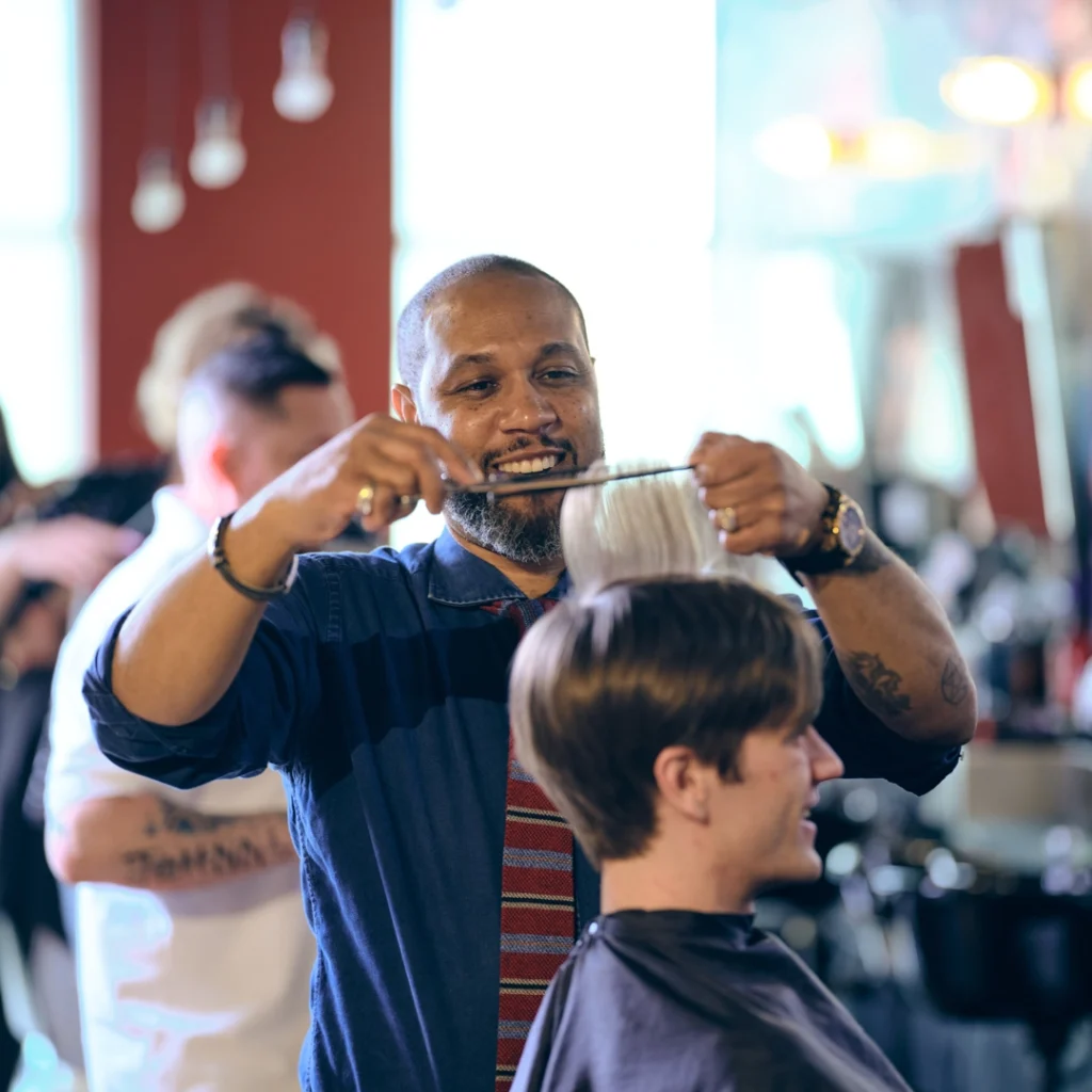 Stylist cuts hair at Floyd's 99 Barbershop.