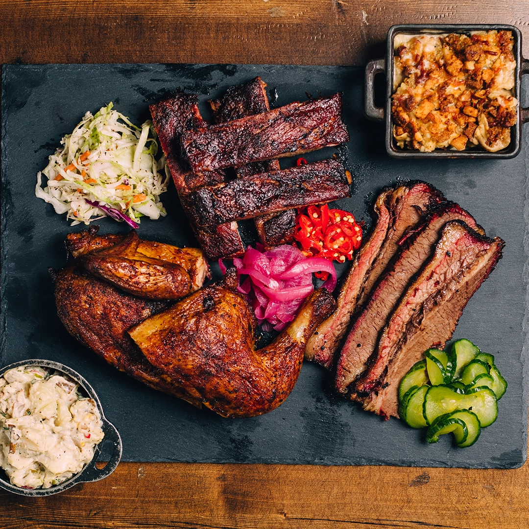 A slate with BBQ variety plate at Mighty Quinn's BBQ.