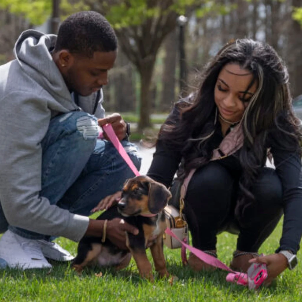 Couple with a puppy in a park.