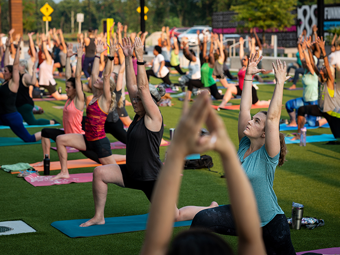 Group of people do yoga class in Color Burst Park at Merriweather Row in Columbia, Maryland.