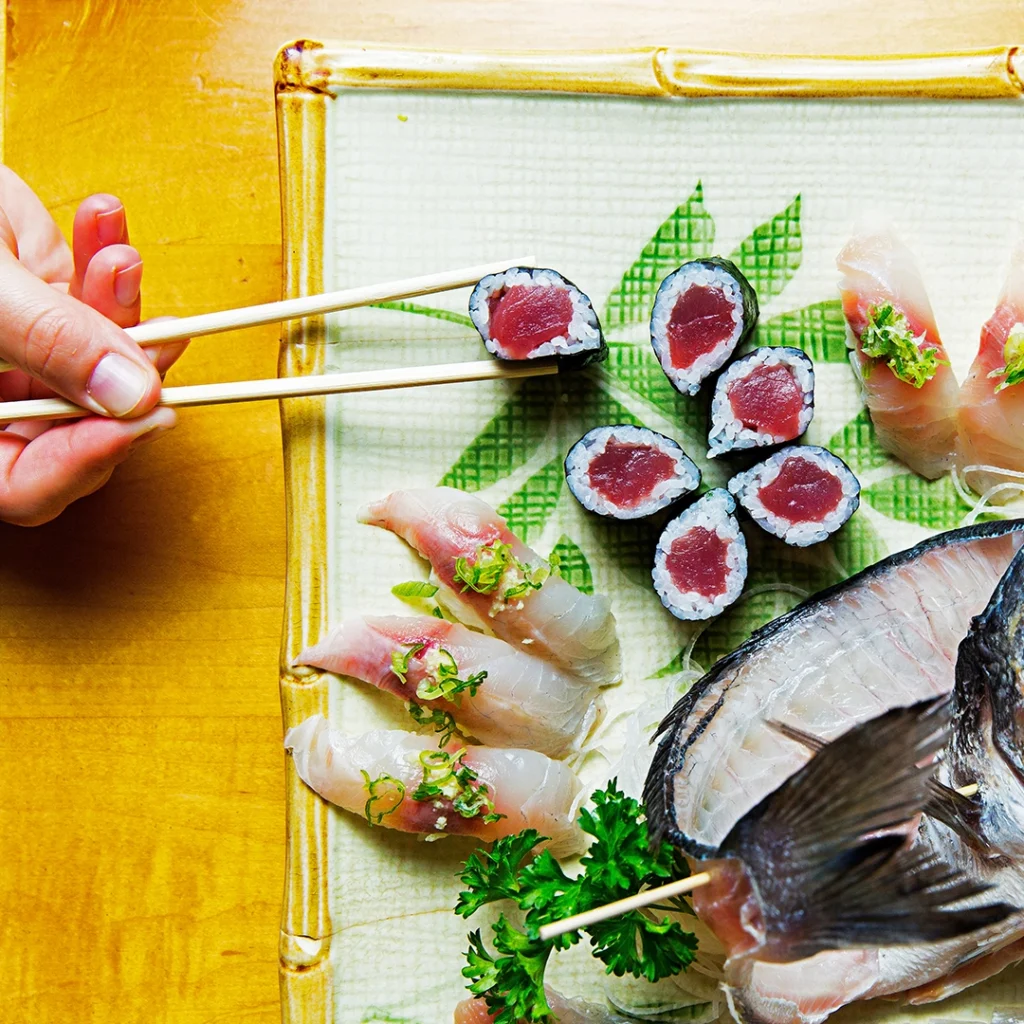 Person uses chopsticks to pick up sushi at Sushi Sono.