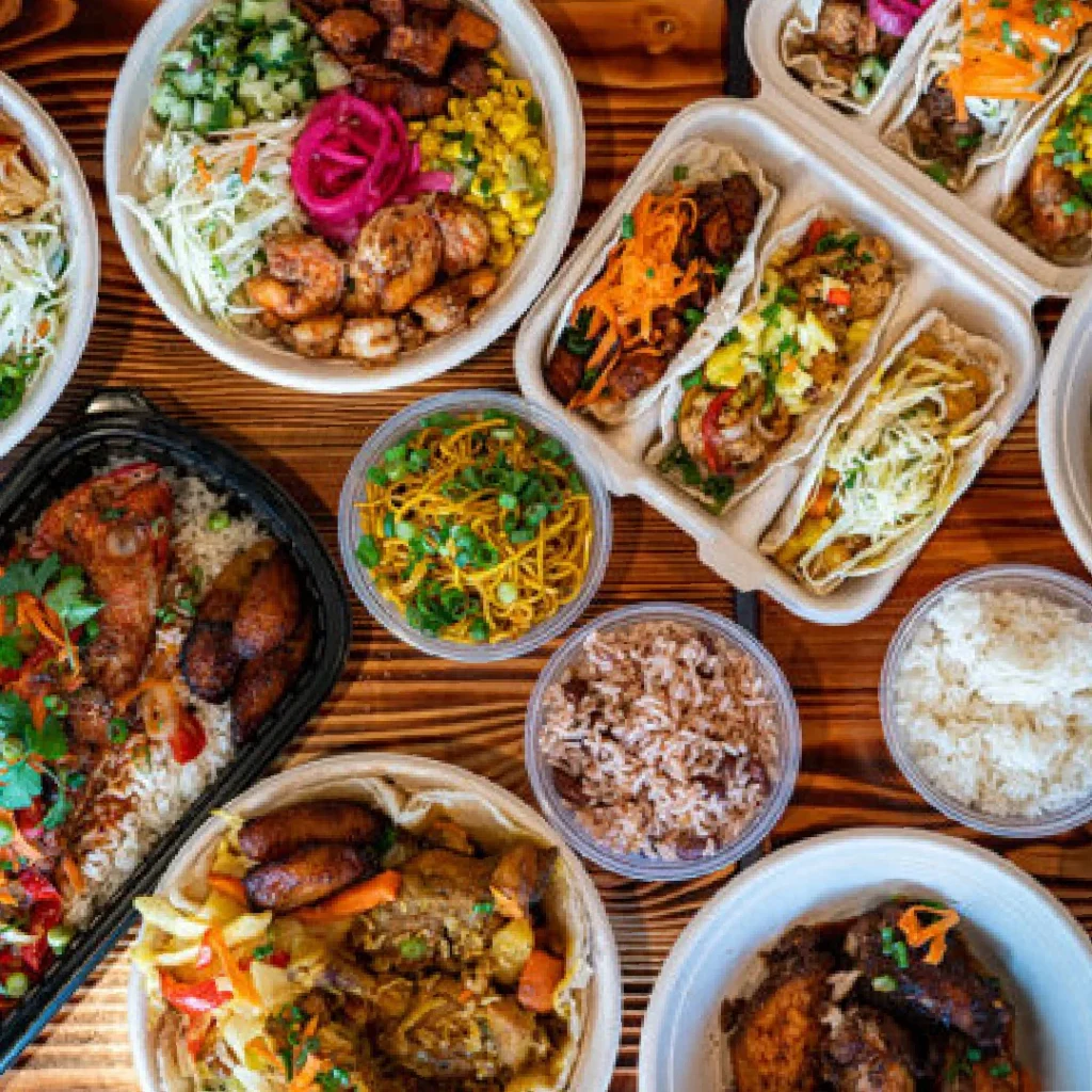 A bunch of bowls and trays of food from The Angry Jerk in Merriweather District, Columbia, Maryland.