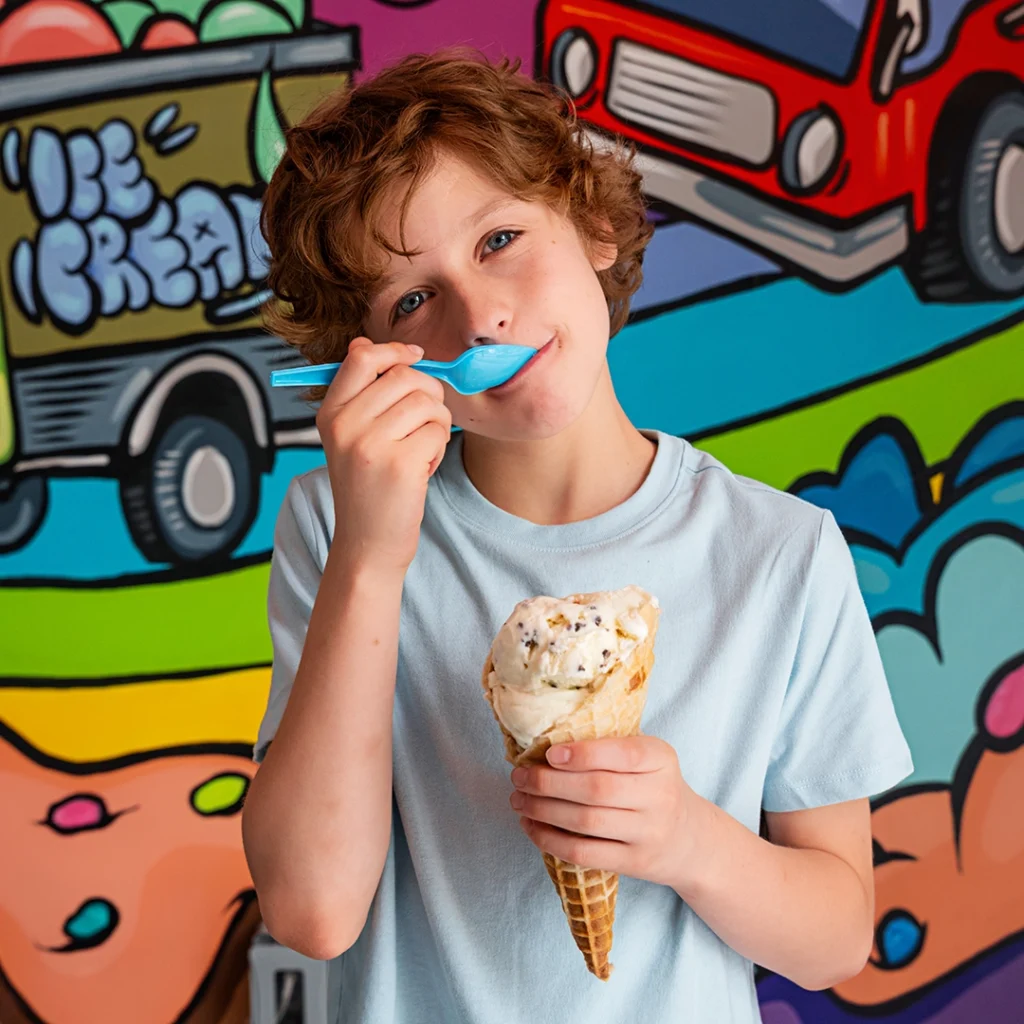Boy eats ice cream at The Charmery at Merriweather District, Columbia, Maryland.