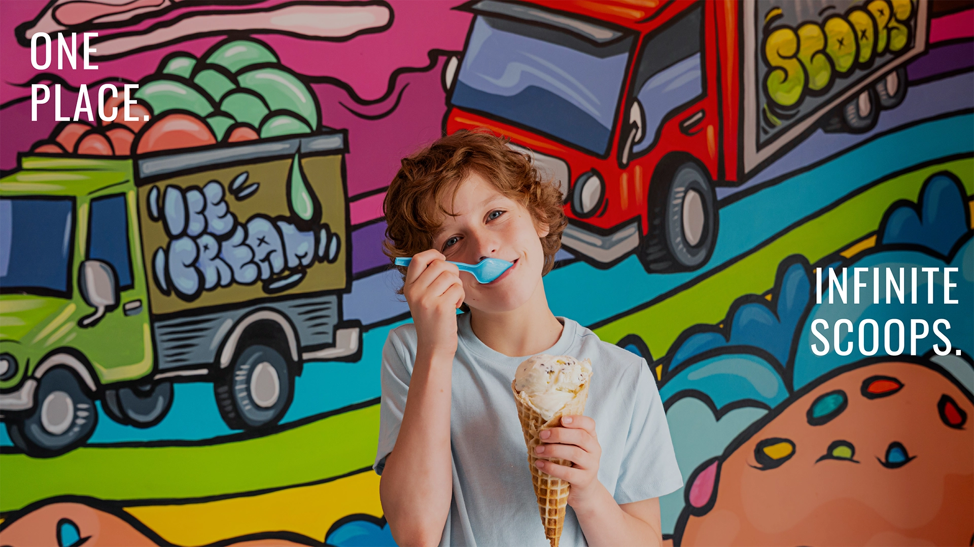 Boy eats ice cream in front of a mural. Text reads "One place. infinite scoops."