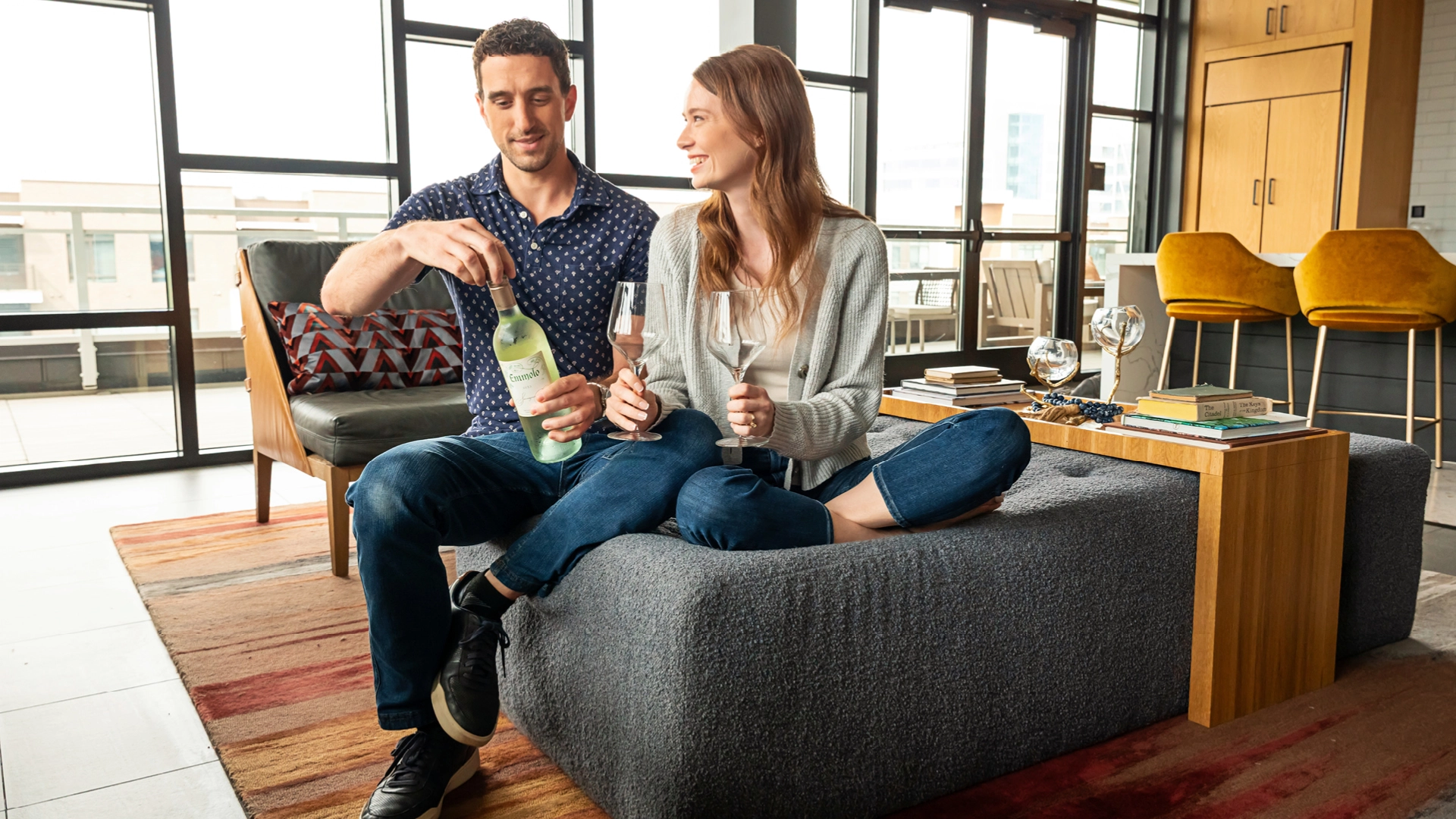 Couple opens a bottle of wine in their apartment at Merriweather District.